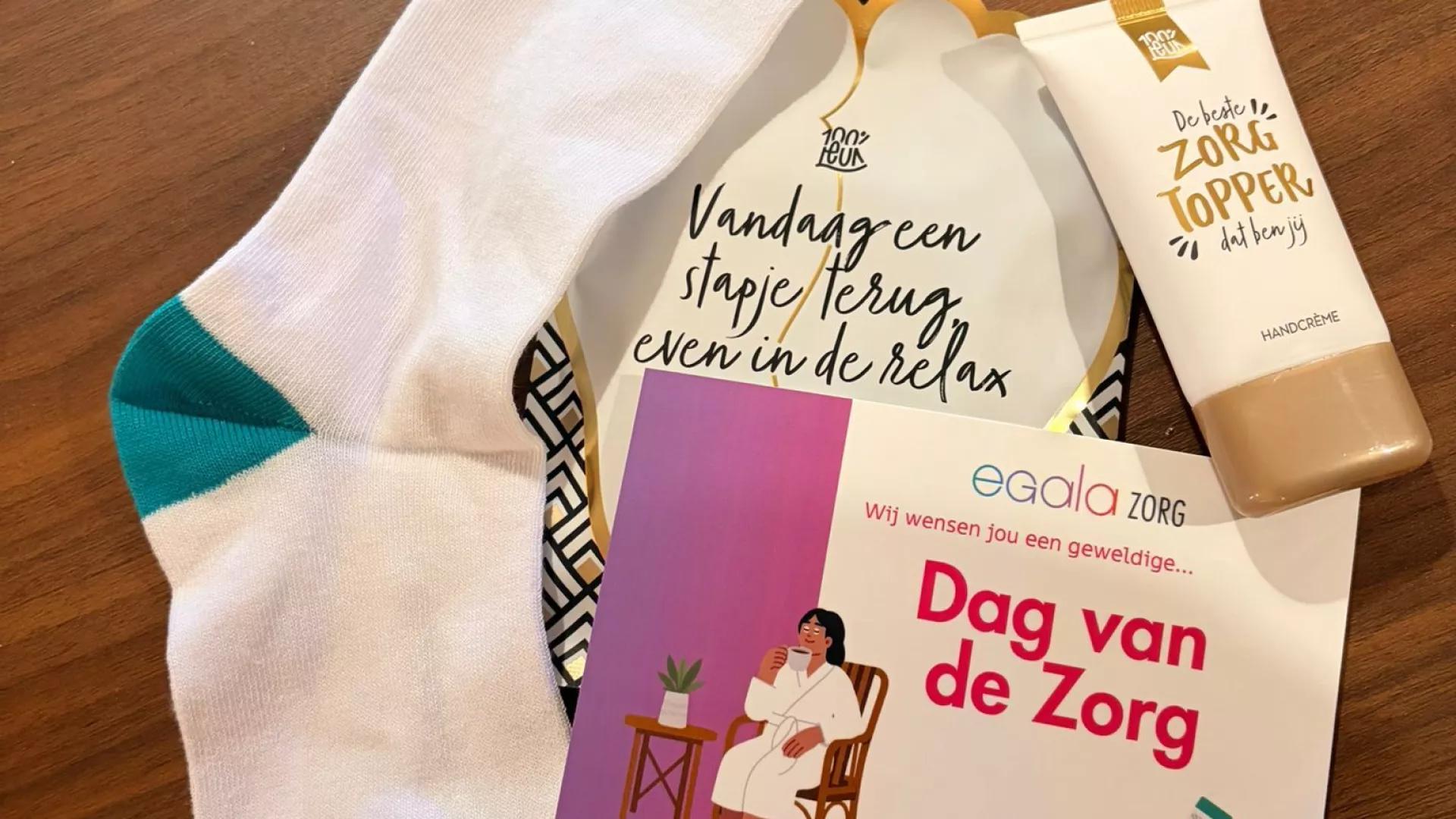 Sokken en verzorgingsproducten op een tafel met een flyer voor "Dag van de Zorg".