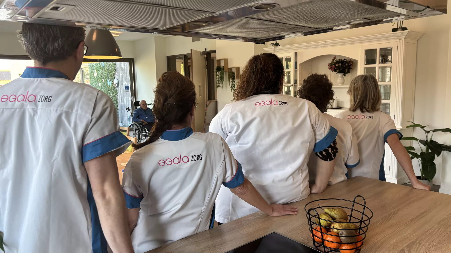 Een team in uniform kijkt naar een opening in de keuken.