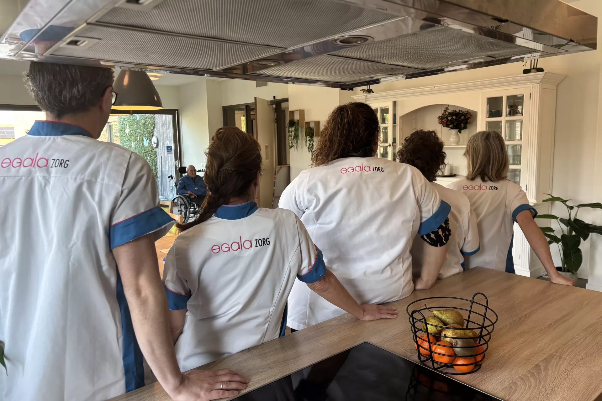 Een team in uniform kijkt naar een opening in de keuken.
